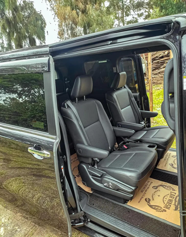 Leather seats inside an executive van with the sliding door open